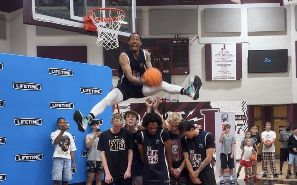 Jonathan Clark dunking over a line of campers at a dunk show