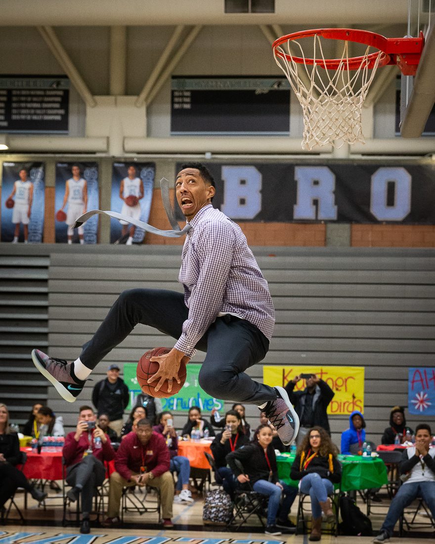 Jonathan Clark dunking in a shirt and tie at a school event